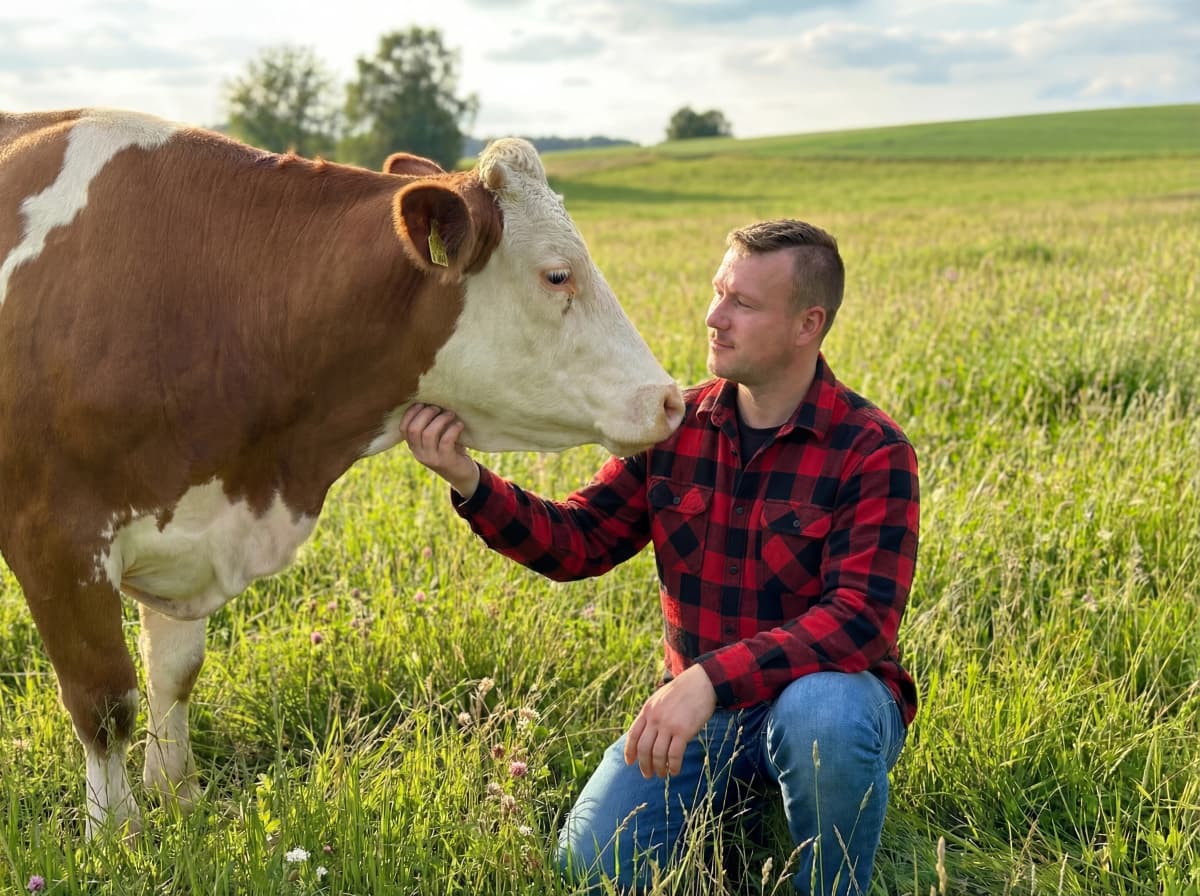 Florian Dreßler mit einer Kuh auf der Weide