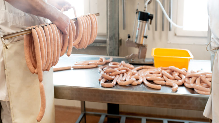 Würste auf einer Haltestange in der Wurstproduktion