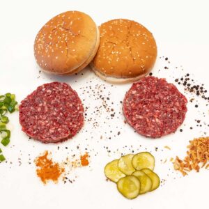 Frische Burger Patties mit diversen Gewürzen, Gurken und Burger Buns