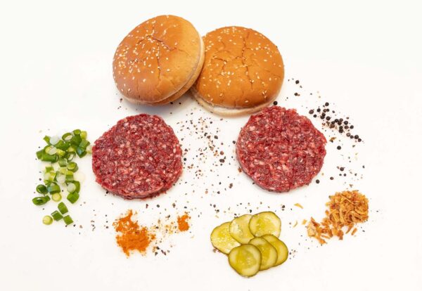 Frische Burger Patties mit diversen Gewürzen, Gurken und Burger Buns